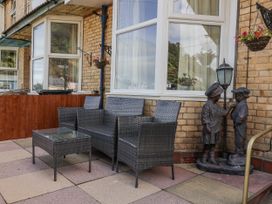 An outdoor seating area with a sofa set and statues at Zide the Zea in Hele Bay, Ilfracombe