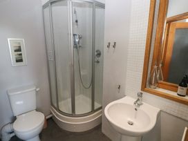 A bathroom with a toilet shower enclosure sink and wooden framed mirror at Zoar Chapel in Carew