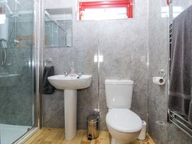 A bathroom with a shower enclosure sink toilet and towels at Smiddy Bothy in Edzell