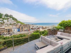 A seating area with a view of houses and ocean at Harbour House in Looe