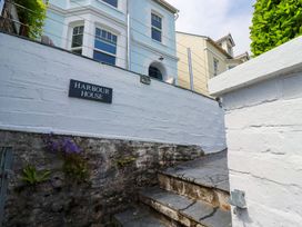 An entrance with a sign for Harbour House in Looe