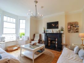 A living room with a fireplace and coffee table at Harbour House in Looe