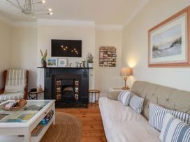 A living room with a fireplace and sofa at Harbour House in Looe