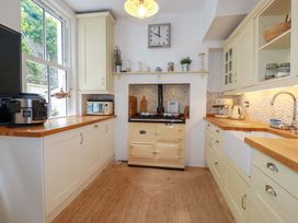A kitchen with cabinets and appliances at Harbour House in Looe