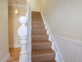 A staircase with carpet and a light fixture at Harbour House in Looe