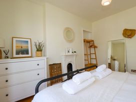 A bedroom with a bed and dresser at Harbour House in Looe