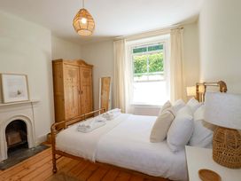 A bedroom with a bed and wardrobe at Harbour House in Looe