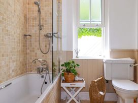 A bathroom with a bathtub and shower at Harbour House in Looe