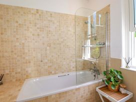 A bathroom with a bathtub and shower at Harbour House in Looe