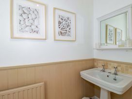 A bathroom with a sink and mirror at Harbour House in Looe