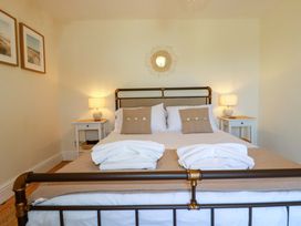 A bedroom with a bed and bedside tables at Harbour House in Looe