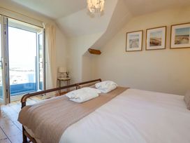A bedroom with a bed and window at Harbour House in Looe
