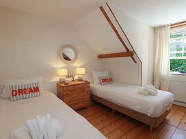 A bedroom with two beds and a nightstand at Harbour House in Looe
