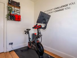 A home gym with an exercise bike and wall storage at Harbour House in Looe