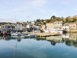 A harbor with boats docked and buildings on the shoreline at Lodge 9- Lamorna Tregolds near St Merryn