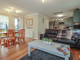 A living room with a dining table and sofa at Lodge 9 - Lamorna in Tregolds near St Merryn