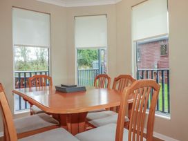 A dining room with a wooden table and chairs at Lodge 9 - Lamorna in Tregolds near St Merryn