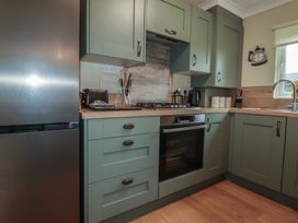 A kitchen with appliances and storage cabinets at Lodge 9 - Lamorna Tregolds near St Merryn