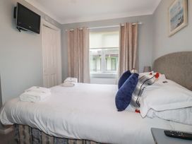 A bedroom with a bed and television at Lodge 9 - Lamorna Tregolds near St Merryn