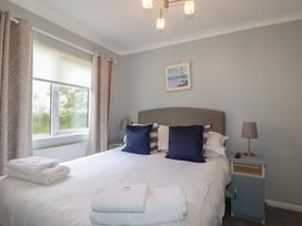 A bedroom with a double bed and window at Lodge 9 - Lamorna Tregolds near St Merryn