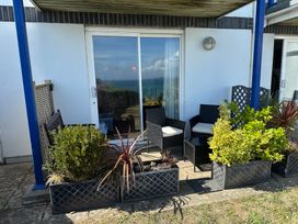 An outdoor seating area with chairs and plants at Tide Watch in Penzance