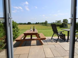 An outdoor seating area with a table and chairs at Honeypot Hideaways - Acacia