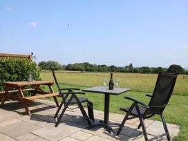 An outdoor seating area with chairs and a table at Honeypot Hideaways - Acacia