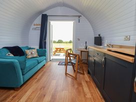 An indoor area with a sofa and kitchen unit at Honeypot Hideaways - Acacia
