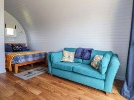 A living room with a bed and sofa at Honeypot Hideaways - Acacia