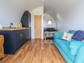 A living room with a kitchen and a bed at Honeypot Hideaways - Acacia