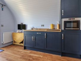 A kitchen with a sink and microwave at Honeypot Hideaways - Acacia