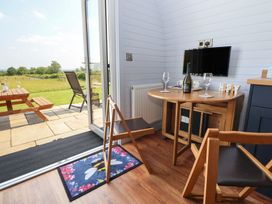 A kitchen with a table and wine glasses at Honeypot Hideaways - Acacia