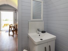 A bathroom with a sink and mirror at Honeypot Hideaways - Acacia