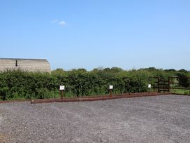 A parking area with gravel and signs at Honeypot Hideaways - Acacia
