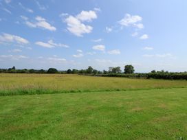 A field with grass and trees at Honeypot Hideaways - Acacia