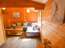A living room with a sofa and coffee table at Stumps Cross Lodge in Upper Coscombe near Winchcombe