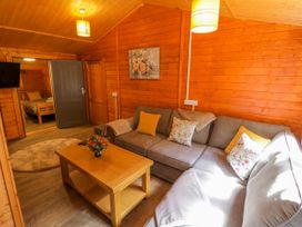 A living room with a sofa and coffee table at Stumps Cross Lodge Upper Coscombe near Winchcombe
