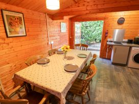 A dining room with a table and chairs at Stumps Cross Lodge in Upper Coscombe near Winchcombe