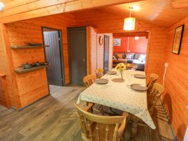 A dining room with a table and chairs at Stumps Cross Lodge Upper Coscombe near Winchcombe