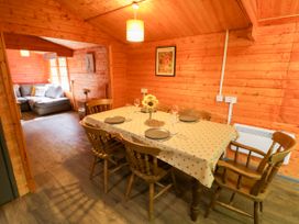 A dining room with a table and chairs at Stumps Cross Lodge Upper Coscombe near Winchcombe