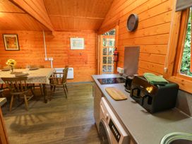 A kitchen with a table and chairs at Stumps Cross Lodge Upper Coscombe near Winchcombe