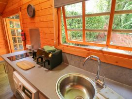 A kitchen with a sink, toaster, and fire extinguisher at Stumps Cross Lodge Upper Coscombe near Winchcombe