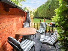 A deck with a table and chairs at Stumps Cross Lodge Upper Coscombe near Winchcombe