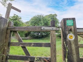 A wooden gate with a sign in a field at Stumps Cross Lodge Upper Coscombe near Winchcombe