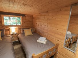 A bedroom with two single beds and a window at Stumps Cross Lodge Upper Coscombe near Winchcombe