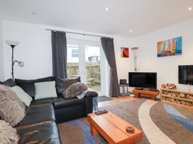 A living room with a sofa and a television at Fistral Palms 2 