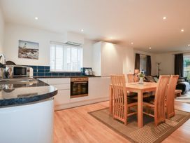 A kitchen with dining table and chairs at Fistral Palms 2