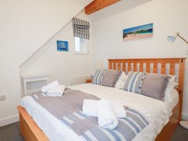 A bedroom with a double bed and bedside table at Fistral Palms 2