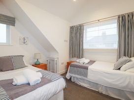 A bedroom with two beds and a lamp at Fistral Palms 2