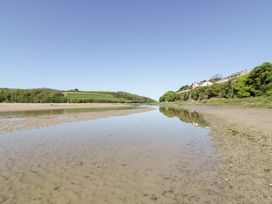 A view of a riverbank with trees and houses at Fistral Palms 2 